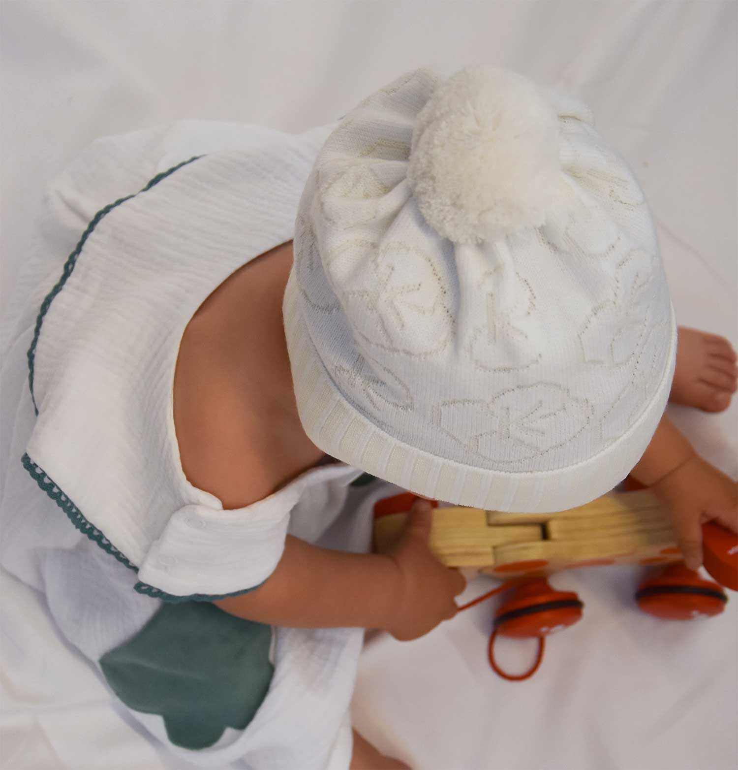 Weiße Babymütze mit Bommel – perfekte Geschenkidee zur Geburt im Winter