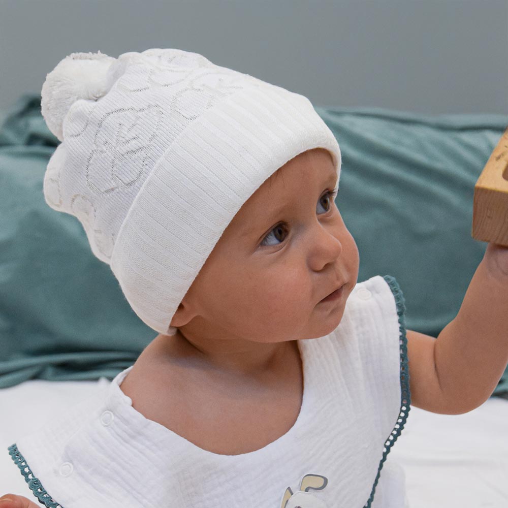 Weiße Baby-Strickmütze mit Bommel – weich, wärmend & süßes Accessoire